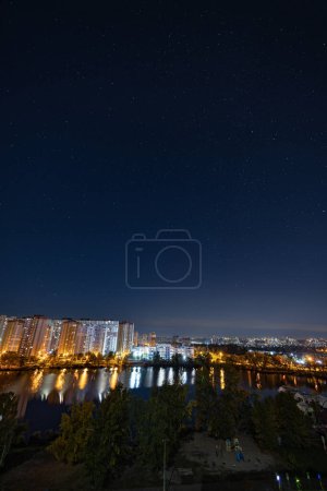 Photo for Night cityscape of the big city under starry sky. Awesome bright, multi colored light at curfew on empty streets. Apartment buildings in bedroom town area. Kyiv in mid october 2022. Ukraine. - Royalty Free Image