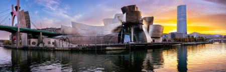 Téléchargez les photos : Bilbao, Espagne - 20 NOV 2021 : superbe vue panoramique du soir sur le musée Guggenheim conçu par Frank Gehry et le remblai Estuaire de Bilbao et gratte-ciel de la société énergétique IBERDROLA - en image libre de droit