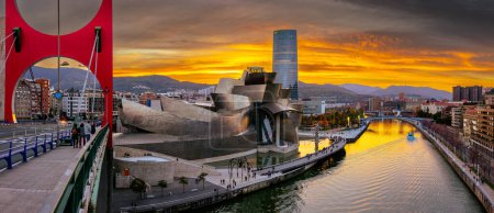 Foto de Bilbao, España - 20 NOV 2021: Impresionante vista panorámica nocturna del Museo Guggenheim diseñado por Frank Gehry y terraplén Estero de Bilbao y rascacielos de la compañía energética IBERDROLA - Imagen libre de derechos