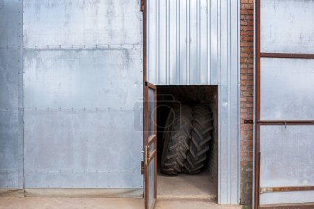 Téléchargez les photos : Deux nouveaux pneus de tracteur à chevrons sont assis dans la remise de la ferme. - en image libre de droit