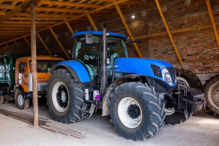 Photo for A new modern blue tractor is parked in a farm hangar. - Royalty Free Image