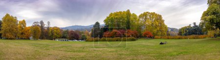 Photo for Turin, Italy - Nov 09, 2021: Panoramic view of the largest lawn in the Parco del Valentino on the banks of the Po river a favorite place for recreation among locals and tourists. Colorful autumn trees - Royalty Free Image