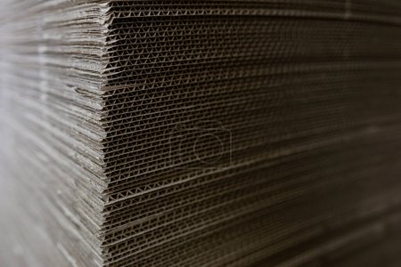 Photo for A cardboard sheets in stack. Perforated sheets of corrugated cardboard are stacked on pallets. Packaging of finished products in industrial production. - Royalty Free Image