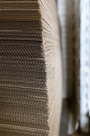 Photo for A cardboard sheets in stack. Perforated sheets of corrugated cardboard are stacked on pallets. Packaging of finished products in industrial production. - Royalty Free Image
