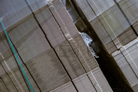 Foto de Cajas de cartón plegables. Las hojas perforadas del cartón ondulado por la pila a las plataformas. Embalaje de productos acabados en producción industrial. - Imagen libre de derechos