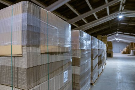 Photo for Folding cardboard boxes. Perforated sheets of corrugated cardboard a stack on pallets. Packaging of finished products in industrial production. - Royalty Free Image