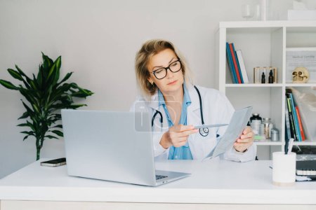 Female doctor makes online video call consult patient on laptop. Middle aged woman therapist videoconferencing for domestic health treatment. Telemedicine concept. Online remote medical appointment