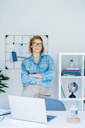 Portrait of 50s stylish, confident mature businesswoman, middle aged company ceo director, experienced senior female professional, business coach team leader in modern office. Female leader. Vertical