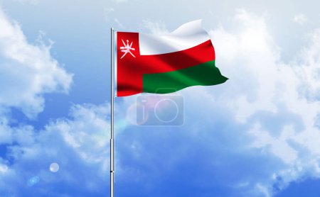 Le drapeau d'Oman agitant sur le ciel bleu brillant