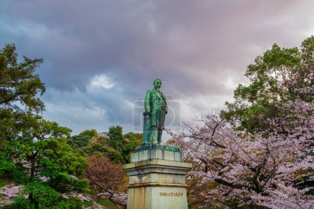 Photo for Tokyo, JAPAN, MARCH 31, 2019 - Shinagawa Yajiro bronze statue among cherry trees in Tokyo Kudanzaka Park - Royalty Free Image