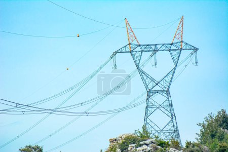 Foto de Pilones eléctricos de alto voltaje y líneas eléctricas de transmisión en el fondo azul del cielo
. - Imagen libre de derechos