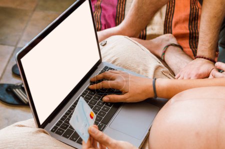 Photo for Unrecognizable pregnant adult woman sitting with her laptop and a card buying newborn products online, typing the card details. - Royalty Free Image