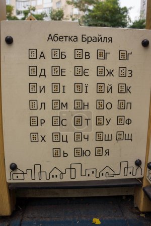 Téléchargez les photos : Alphabet ukrainien en braille sur l'aire de jeux. Inscription sur le tableau en ukrainien "alphabet braille". Fonte braille en ukrainien est encadrée à l'extérieur - en image libre de droit