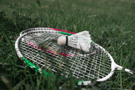 Photo for Close-up of shuttlecock and rackets for badminton on green grass outdoors. Badminton equipment. Break in the game Outdoor recreation and sports concept. - Royalty Free Image