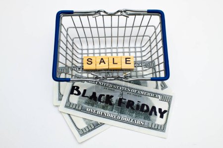 Téléchargez les photos : Vente Black Friday concept de shopping. Panier avec billets en dollars - en image libre de droit
