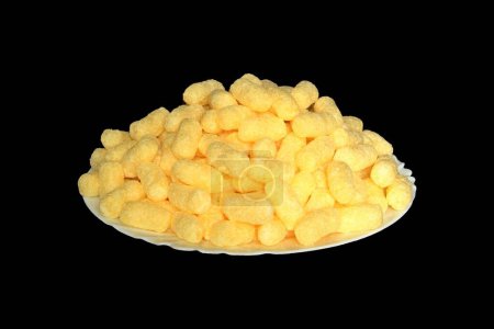 Foto de Palitos de maíz dulce en un plato blanco sobre un fondo negro. Vista axonométrica. - Imagen libre de derechos