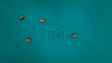 Foto de Pequeño barco o balsa turista flotando sobre fondo de color verde agua, fotografía mínima para poscard y bacground abstrac concepto, vista aérea superior de drone - Imagen libre de derechos