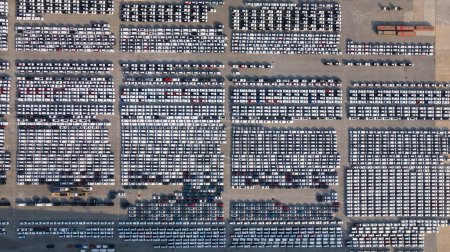 Foto de Vista aérea de los coches nuevos se alinean estacionados en la zona de aparcamiento de la fábrica de automóviles, a la espera de transporte RORO de internacional, - Imagen libre de derechos