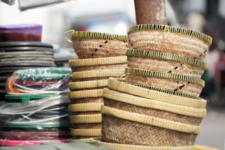 rice baskets made from woven bamboo are stacked for sale. defocused