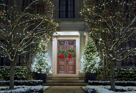 Vorgarten des Hauses mit dekorativen Weihnachtslichtern an Bäumen im Winter