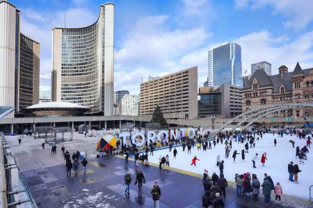 Foto de Toronto, Canadá - Diciembre 2022: La pista de patinaje gratuita en la plaza del Ayuntamiento es una atracción popular, con alquiler de patines disponibles. - Imagen libre de derechos