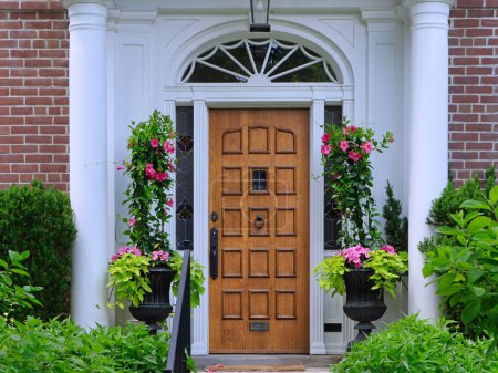 Hermosa puerta de entrada de grano de madera del hogar, rodeado de flores