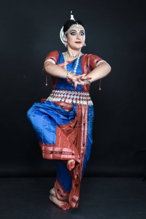 Foto de Mujer realizando danza Odissi en traje colorido. Formas de danza clásica india. - Imagen libre de derechos