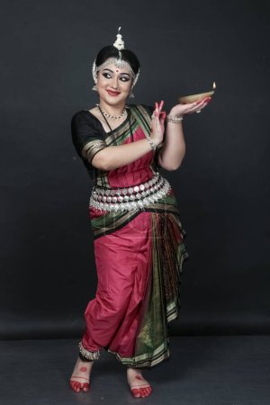Téléchargez les photos : Danseuse indienne odishi célébrant Diwali ou deepavali, fête des lumières au temple. Femme mains tenant lampe à huile. - en image libre de droit
