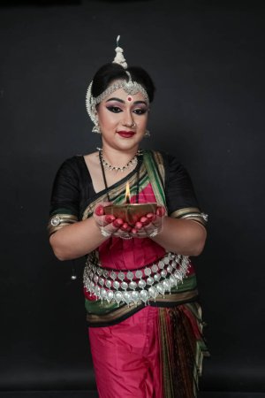 Foto de Bailarina india de odishi que celebra Diwali o deepavali, festividad de luces en el templo. Manos femeninas sosteniendo lámpara de aceite. - Imagen libre de derechos