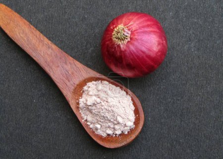 Red Onion powder on wooden spoon 