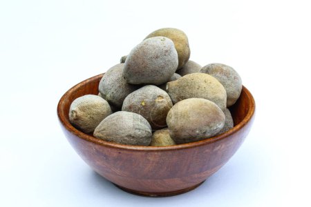 Terminalia bellirica or baheda fruits in a wooden bowl 