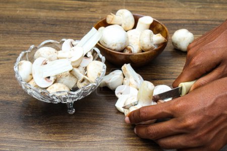 Cutting some white mushrooms white hand 