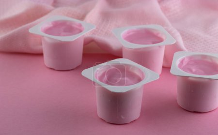 Pink yogurt, strawberry flavoured yogurt isolated on pink background with space for text