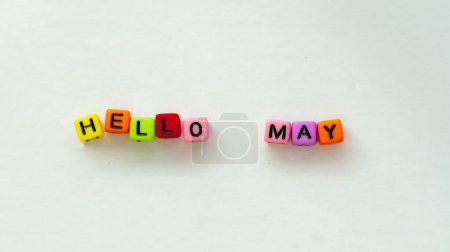 May coming and changing April. Spring concept. Colorful letter beads on white background. . High quality photo. Top view. Horizontal greeting postcard. Mock up template copy space.
