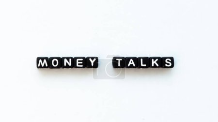 Foto de Money talks quote in black letter beads on white background. Wealth and money concept. High quality photo. Horizontal. Mock up, template, copy space. - Imagen libre de derechos