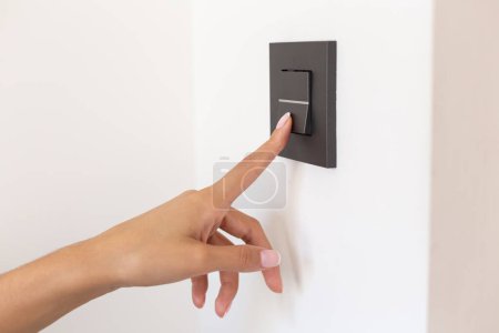 Foto de Primer plano de la mano de la joven presionando el botón del interruptor de luz - Imagen libre de derechos