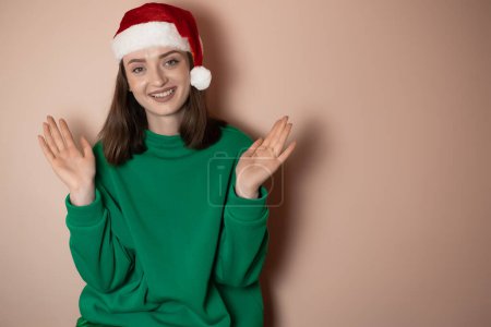 Téléchargez les photos : Joyeux jeune femme porter chandail de Noël Santa chapeau posant faire geste gagnant célébrer les poings serrés dire oui isolé sur fond vert clair pastel simple Bonne année 2023 célébration concept de vacances - en image libre de droit