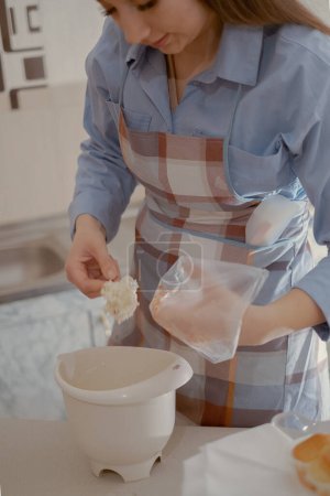 A female pastry chef prepares frosting for cupcakes. Enjoy the art of home baking with this homemade pastry chef crafting delicious treats at home.