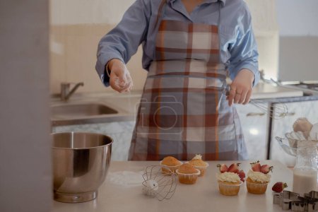 A female pastry chef prepares dough, sprinkling flour, showcasing homemade baking. Explore the charm of small-scale, eco-friendly baking with gluten-free and sugar-free products, promoting healthy eating.
