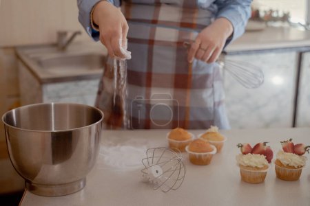 A female pastry chef prepares dough, sprinkling flour, showcasing homemade baking. Explore the charm of small-scale, eco-friendly baking with gluten-free and sugar-free products, promoting healthy eating.