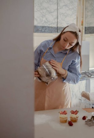 A female pastry chef whips cream for a pie, highlighting homemade baking. Experience the essence of small-scale, eco-friendly baking with gluten-free and sugar-free products, promoting healthy eating.