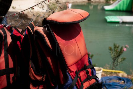 Life jackets hanging against the backdrop of the sea. For sale: lifesaving equipment for marine excursions and tours, emphasizing safety on cruises and yacht outings. Marine services and training.