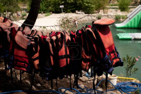 Life jackets hanging against the backdrop of the sea. For sale: lifesaving equipment for marine excursions and tours, emphasizing safety on cruises and yacht outings. Marine services and training.
