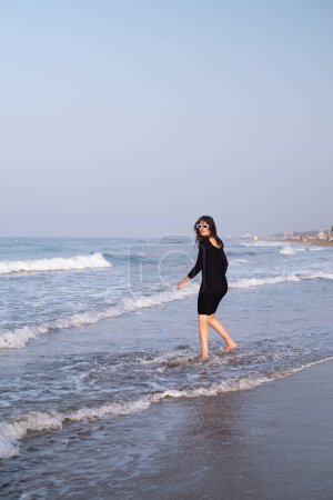 A joyful girl runs along the seaside, attracting tourists to coastal resorts and hotels, highlighting the beauty and tranquility of the coastline.