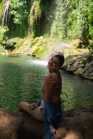 Chica goza de cascada en la reserva natural, perfecto para el turismo, excursiones, excursiones de aventura, ocio extremo, parques nacionales y reservas.