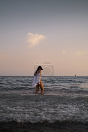 Girl swims in the sea, epitomizing calmness and relaxation. Promotes tourism, resorts, healthy lifestyle, and outdoor sports.
