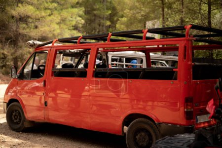 Ein roter offener Touristenbus steht im Wald. Verwendet für Reisebüros, Bustouren, Ausflüge, Routenprogramme, Führer, Broschüren und Sehenswürdigkeiten.