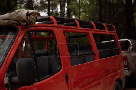Téléchargez les photos : Un bus touristique rouge à toit ouvert se trouve dans la forêt. Utilisé pour les agences de tourisme, visites en bus, excursions, programmes d'itinéraires, guides, brochures et monuments. - en image libre de droit