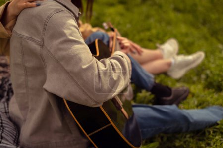 Festival de música al aire libre con un hombre tocando la guitarra en un camping. Atracciones turísticas, rutas y actividades al aire libre saludables para un estilo de vida activo.