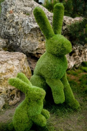 Green bushes trimmed into rabbit shapes, topiary gardens, featuring green Easter bunnies.